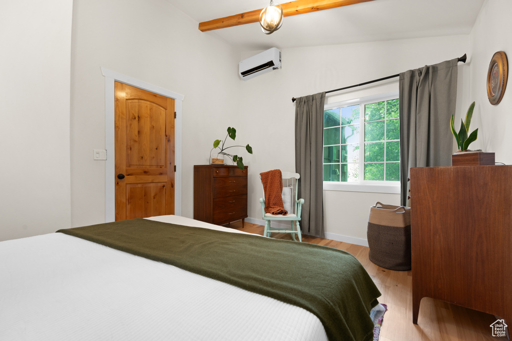 Bedroom featuring a wall mounted air conditioner and wood finished floors