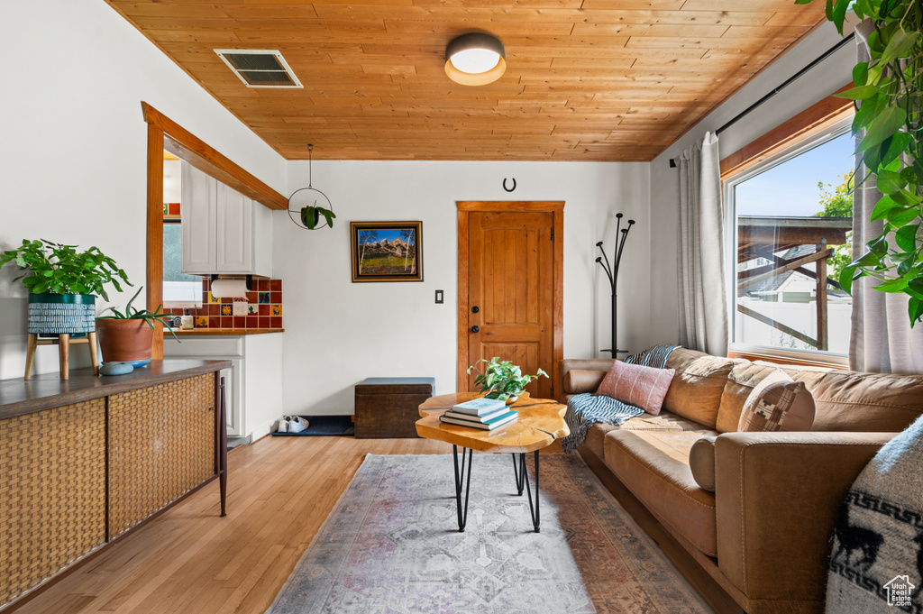 Living room with wood ceiling and light wood-type flooring