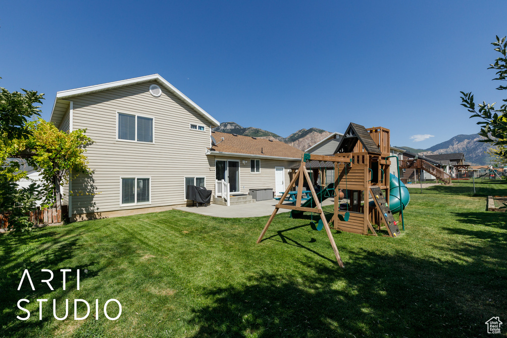Rear view of house with a playground, a patio, a mountain view, and entry steps