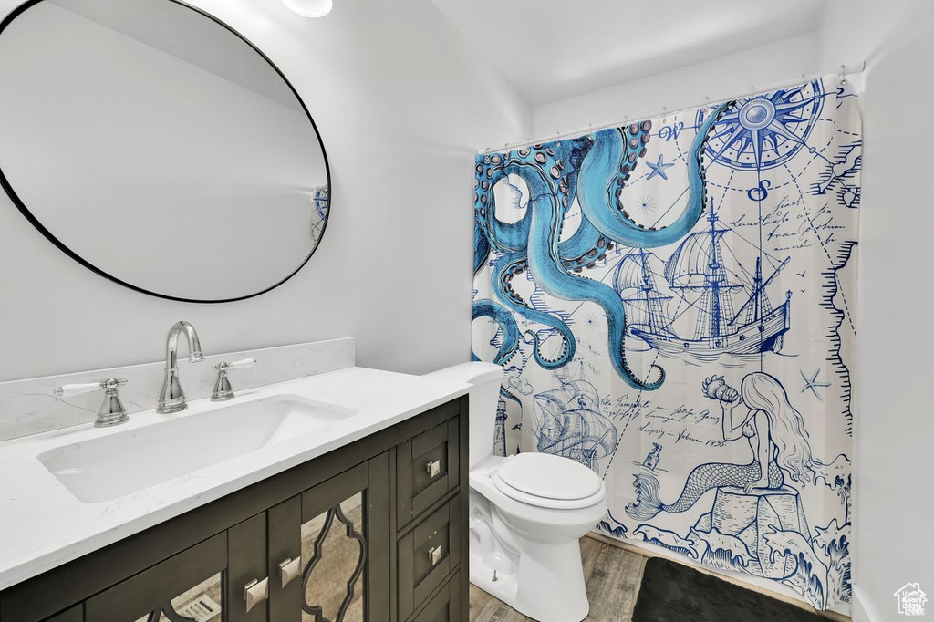 Bathroom with vanity, wood finished floors, and a shower with curtain