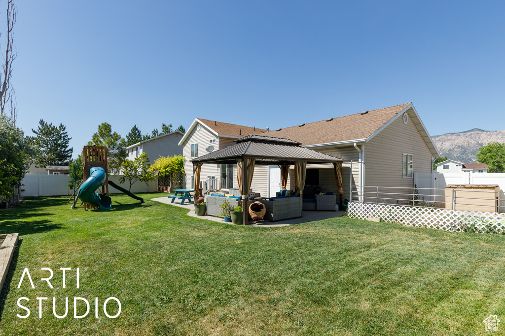 Rear view of property featuring an outdoor living space, a gazebo, a playground, a patio area, and a fenced backyard