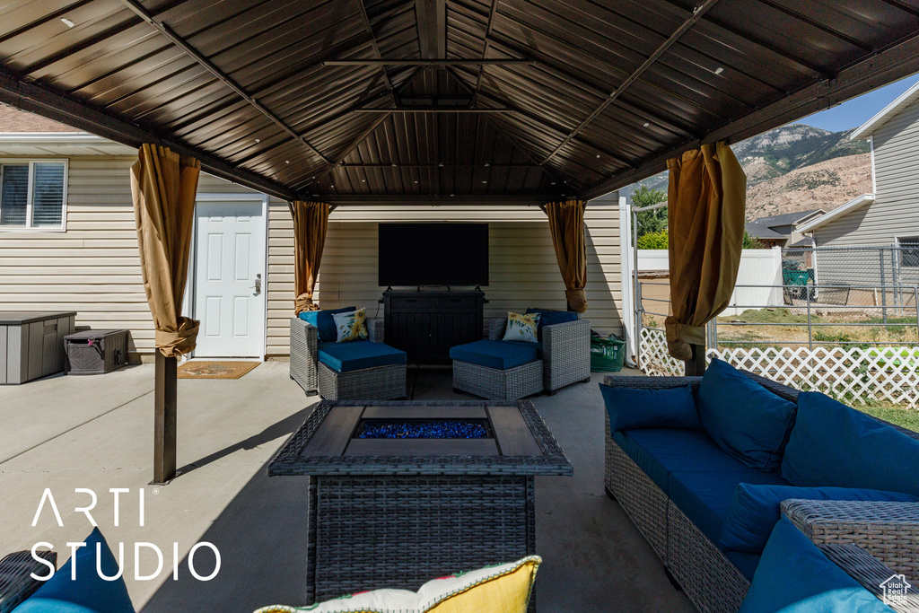 View of patio with an outdoor living space with a fire pit and a gazebo