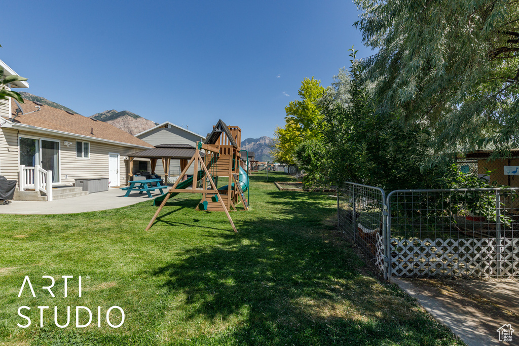 View of yard with a playground, a patio area, a mountain view, and a gazebo