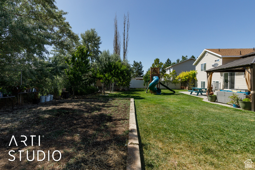 Fenced backyard featuring a playground and a gazebo