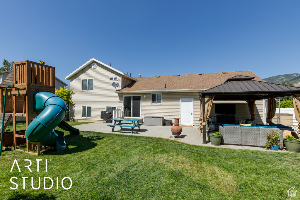 Back of property featuring an outdoor living space, a patio, a gazebo, a yard, and a shingled roof