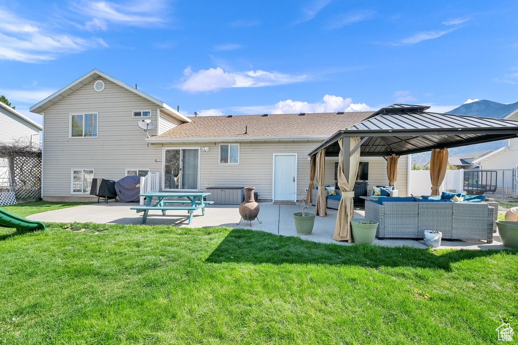 Rear view of house with outdoor lounge area, a patio, and a gazebo