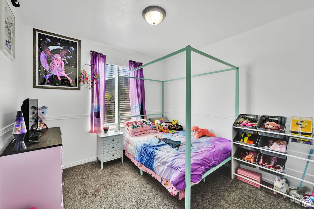 Bedroom featuring carpet and baseboards
