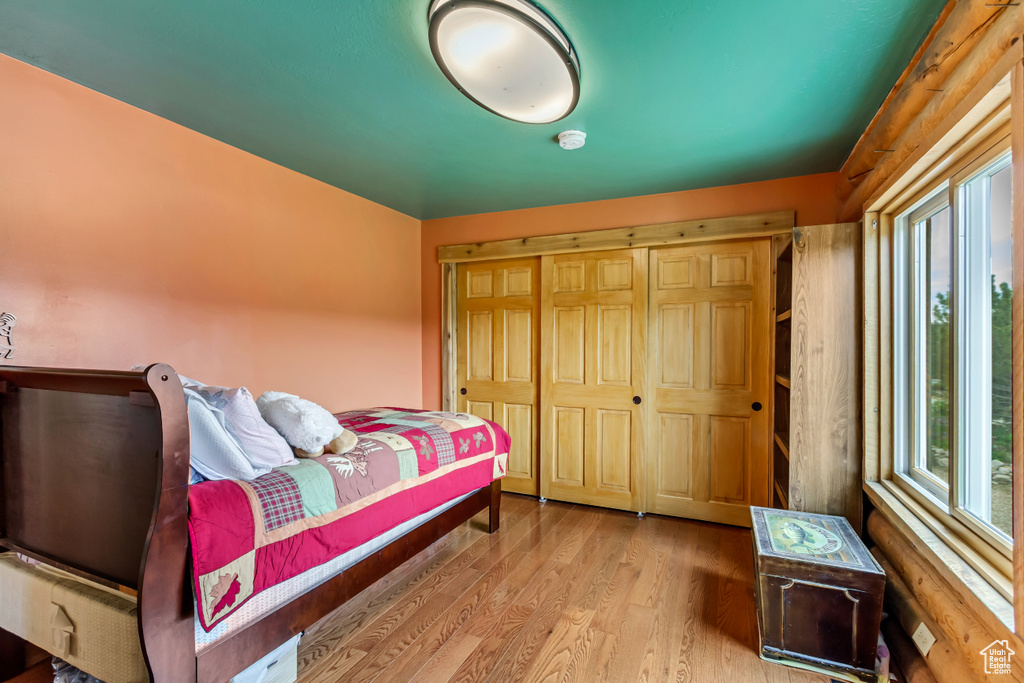 Bedroom with multiple windows and wood finished floors
