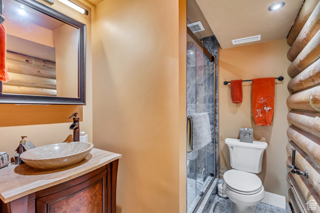 Bathroom with vanity, a stall shower, and log walls
