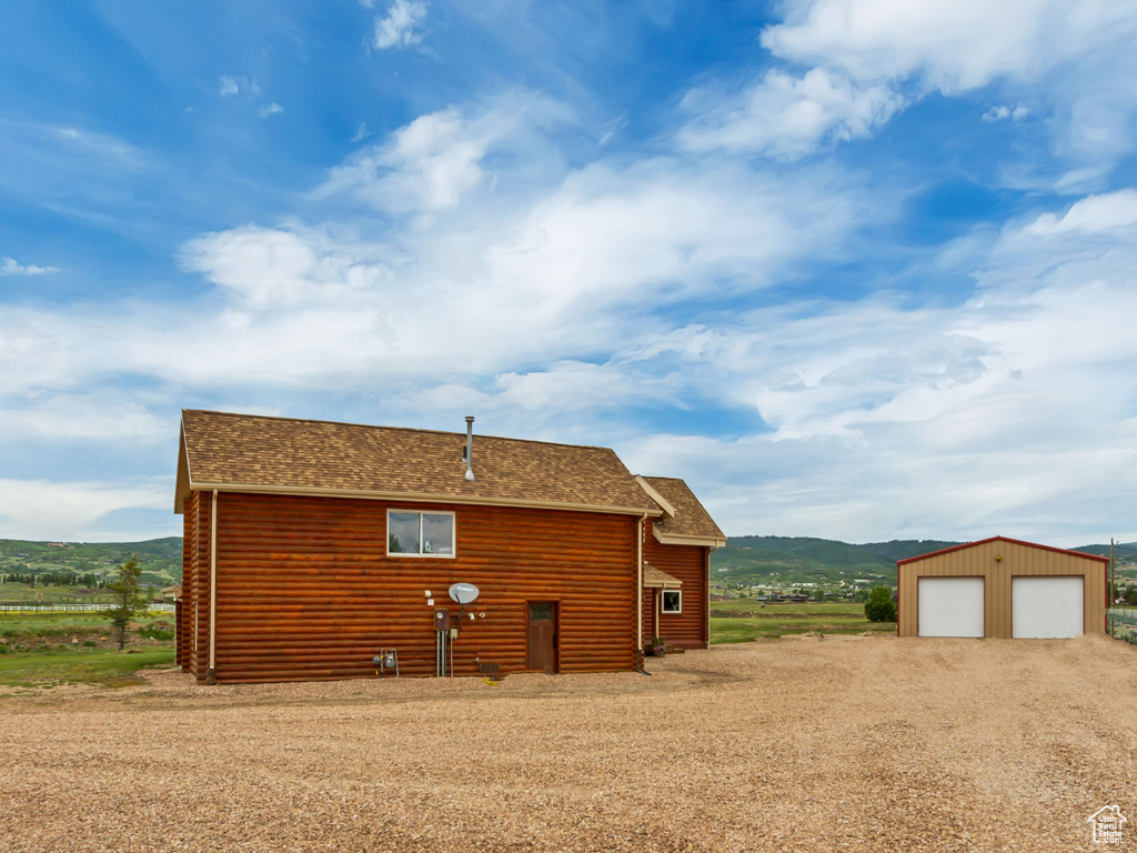 View of outdoor structure featuring dirt driveway and a mountain view