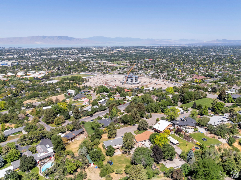 Aerial view of property and surrounding area featuring a mountainous background