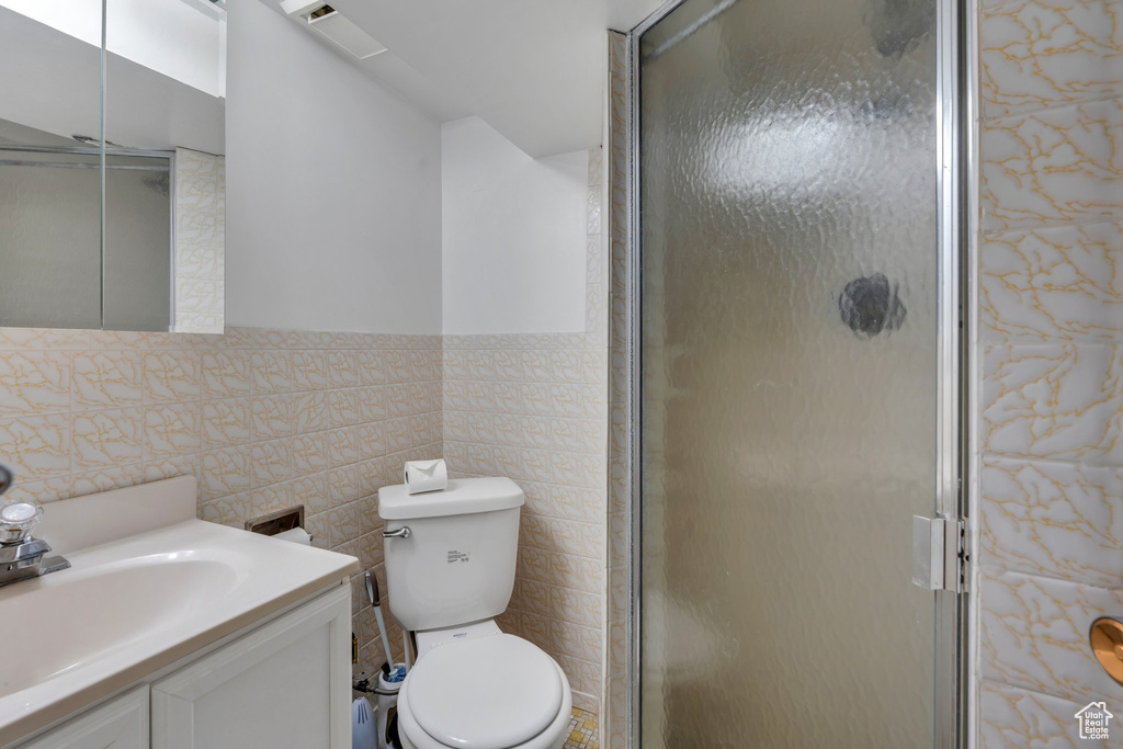Full bath with vanity, tile walls, and a stall shower