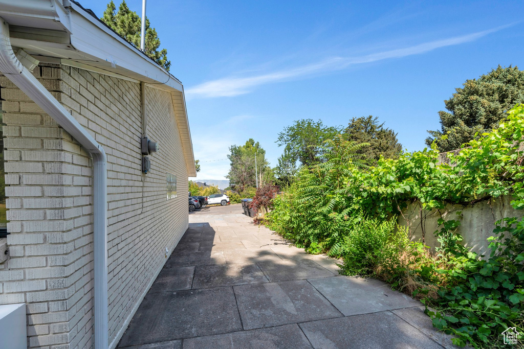 View of side of property featuring brick siding and a patio area