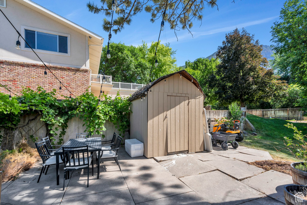 Patio / terrace featuring a shed, a patio, and outdoor dining space