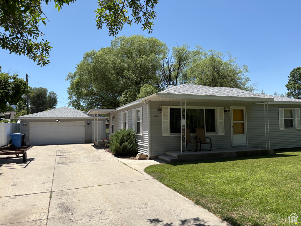 View of front of property with a porch, a garage, a front lawn, concrete driveway, and a shingled roof