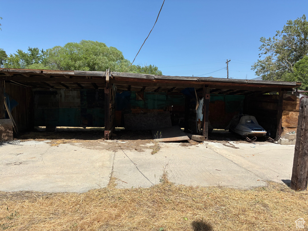 View of patio featuring concrete driveway and a carport
