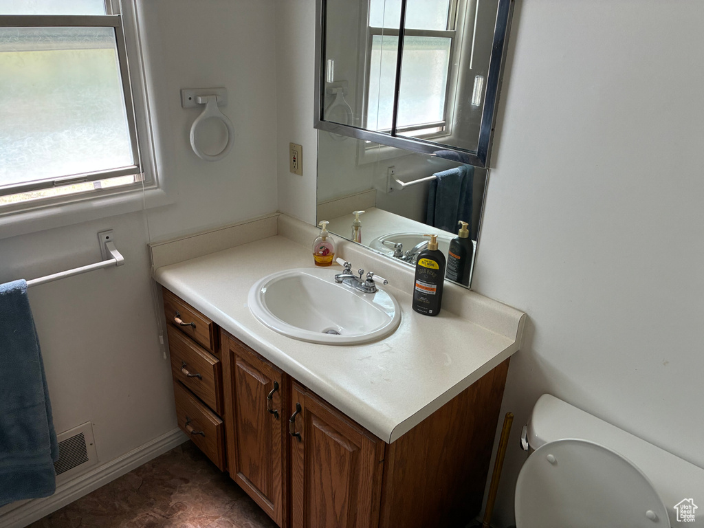 Half bathroom featuring healthy amount of natural light and vanity