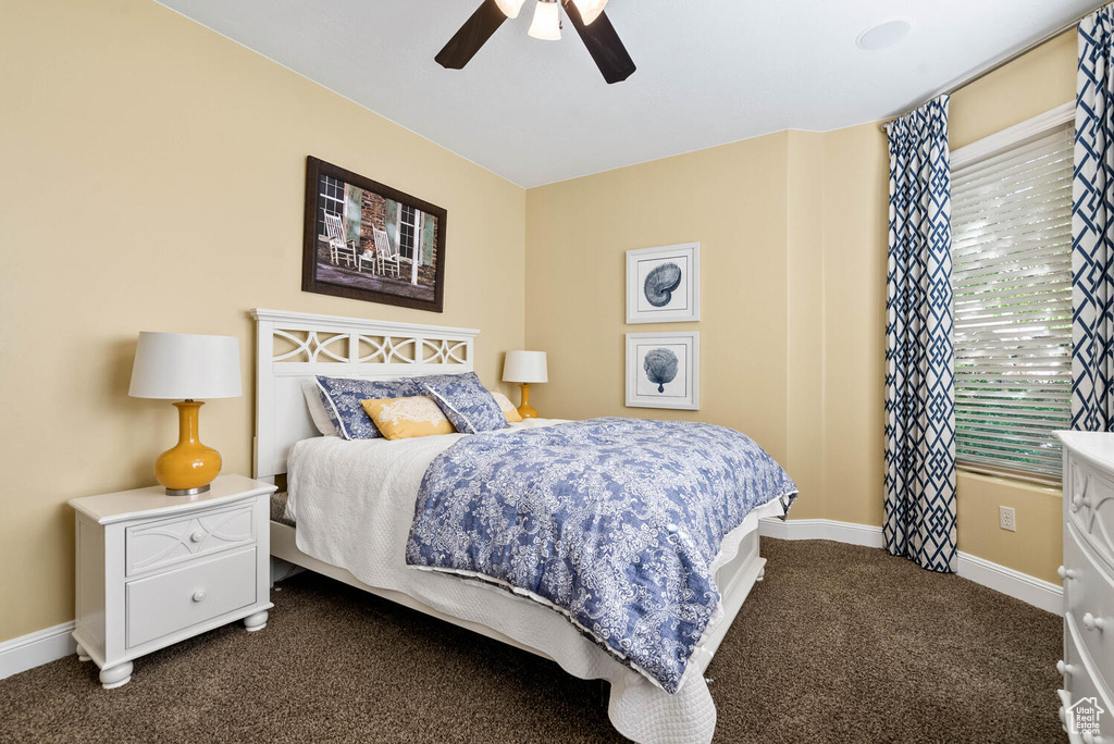Bedroom with dark colored carpet and ceiling fan