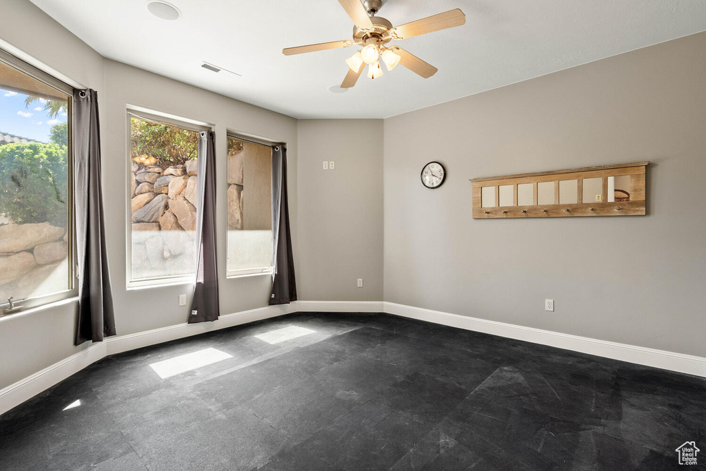Empty room featuring baseboards and ceiling fan