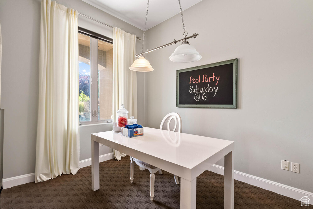 Dining space featuring baseboards and dark colored carpet