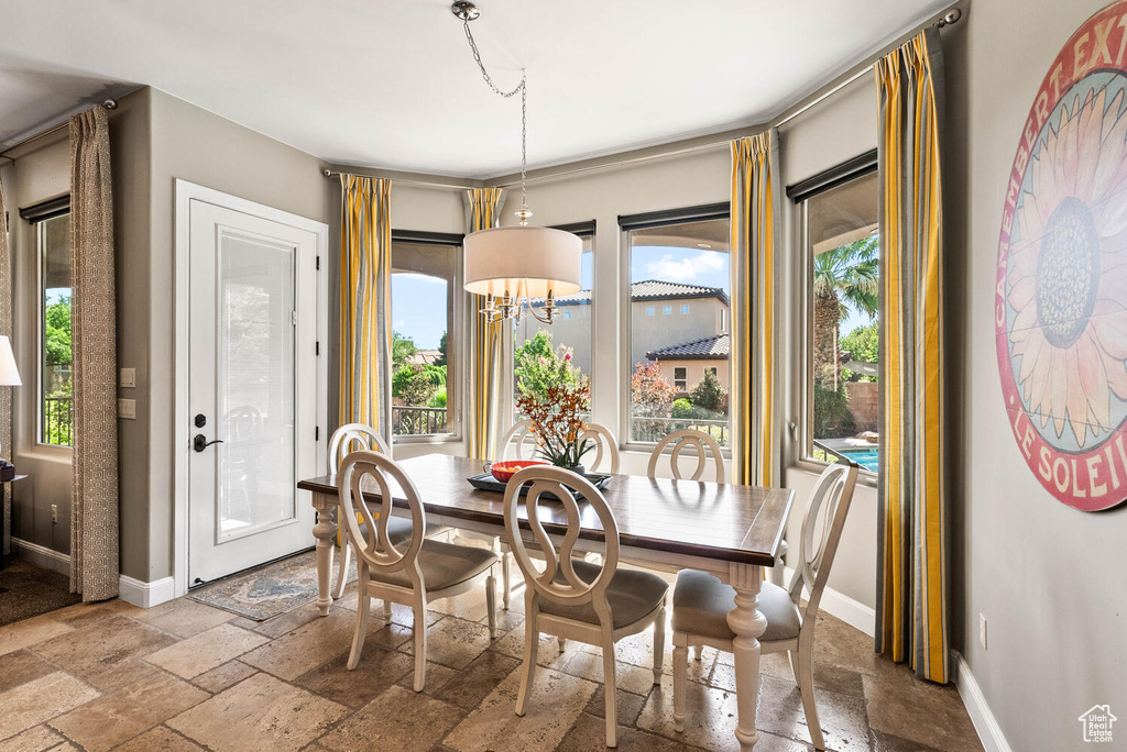 Dining area with stone tile floors and a chandelier