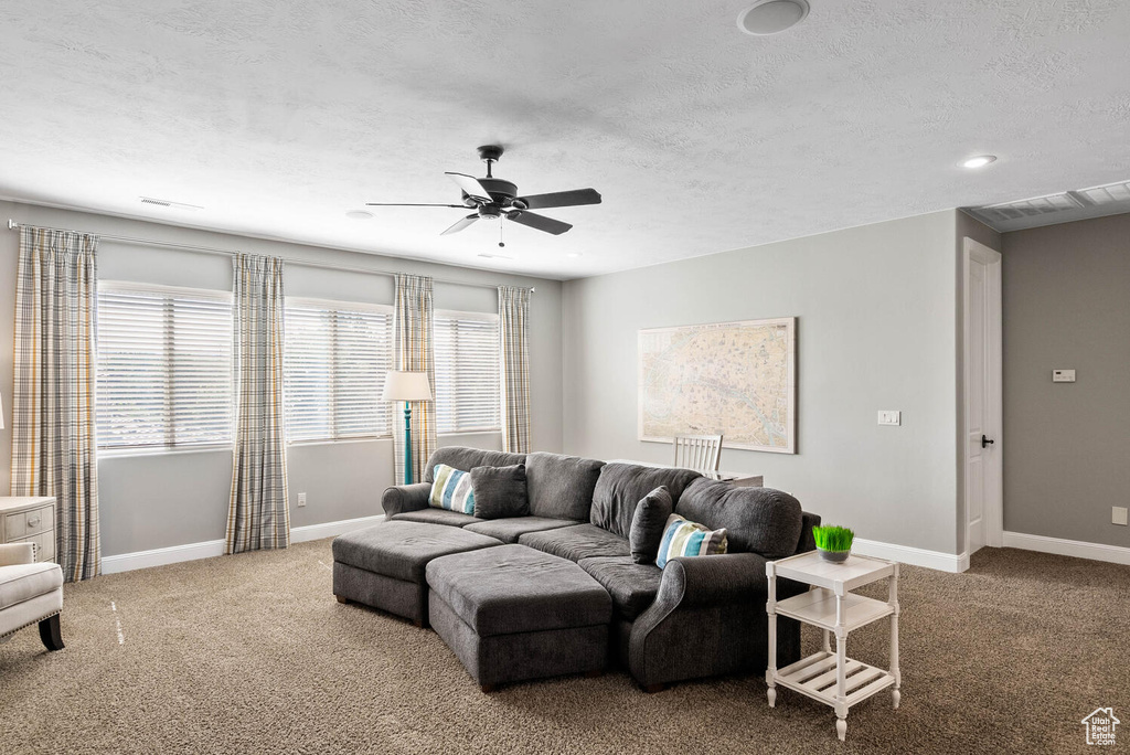 Living area with ceiling fan, carpet flooring, a textured ceiling, and recessed lighting