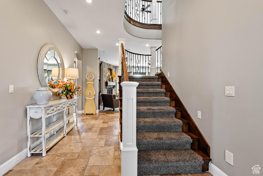 Stairs featuring stone tile floors and recessed lighting