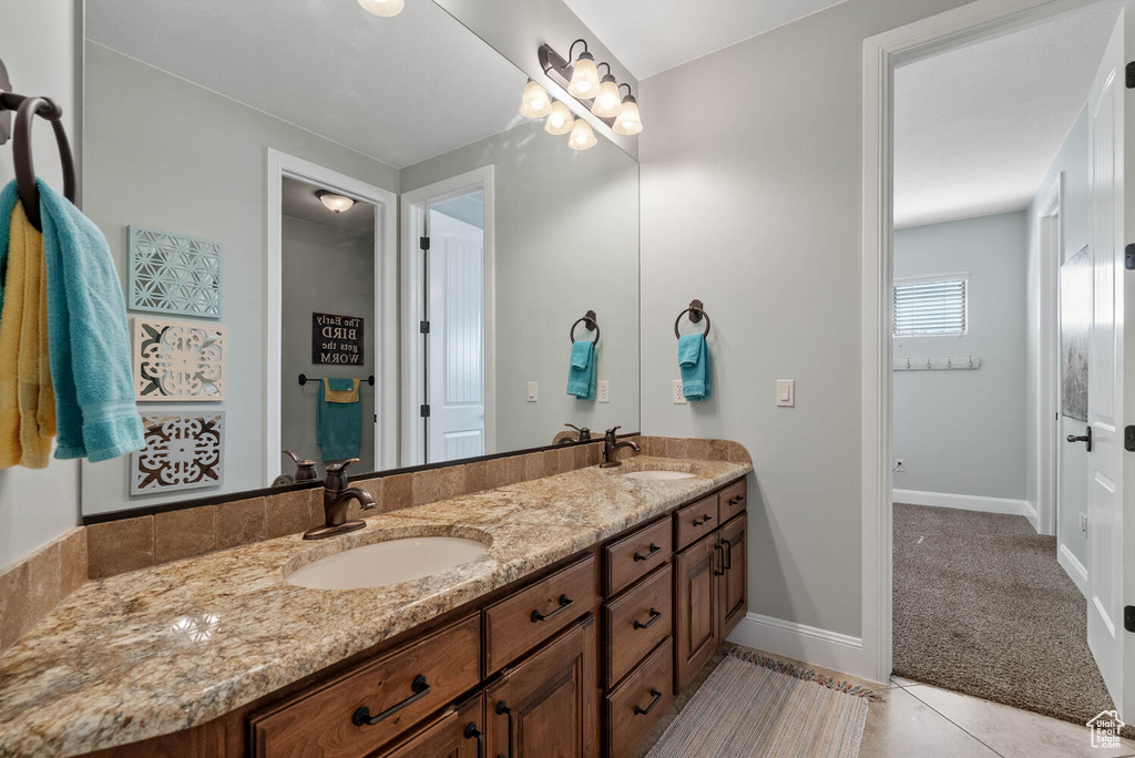 Full bath featuring double vanity and tile patterned flooring