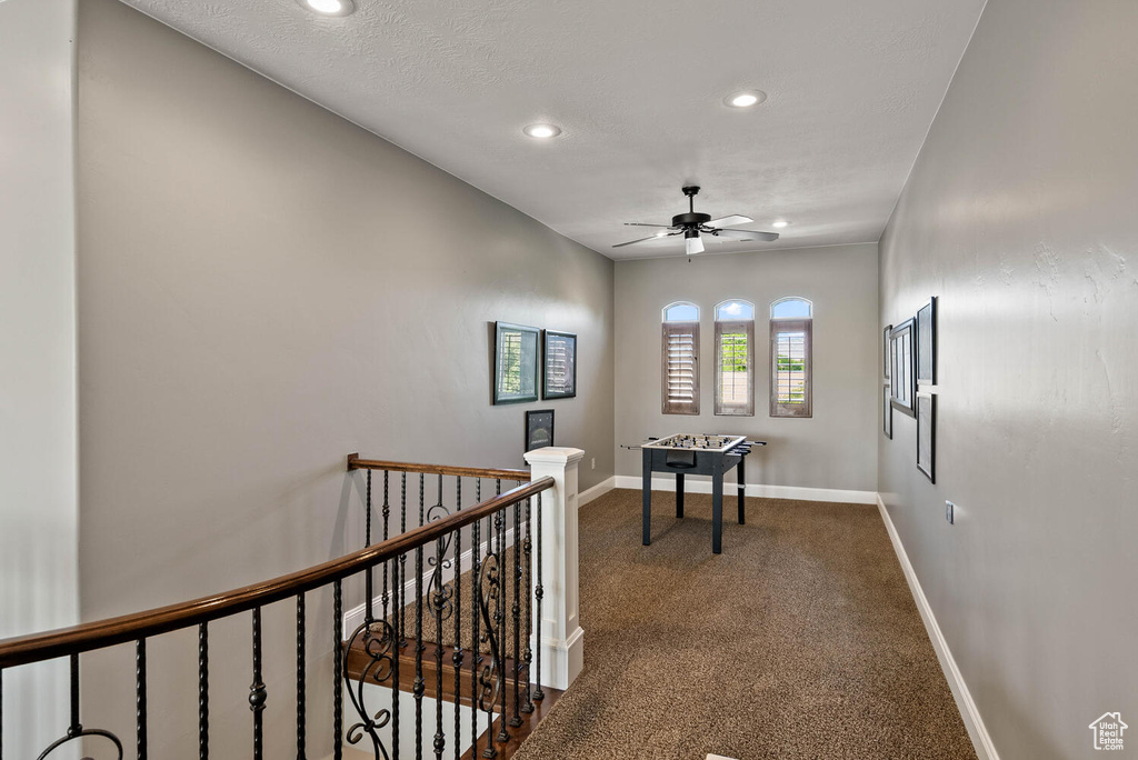 Hallway with an upstairs landing, recessed lighting, and carpet