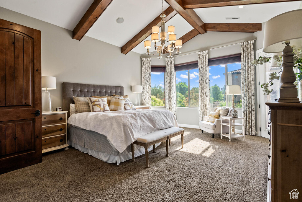 Bedroom with dark carpet and a chandelier