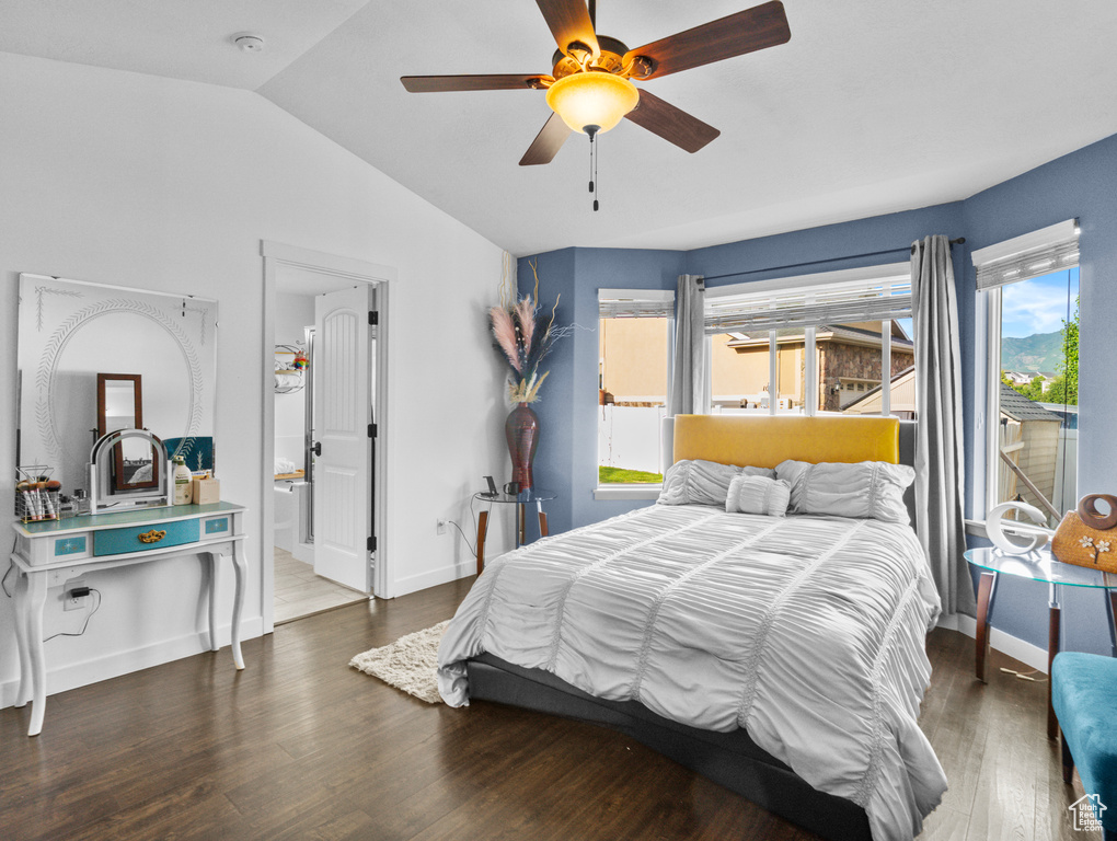 Bedroom featuring vaulted ceiling, wood finished floors, ceiling fan, and connected bathroom