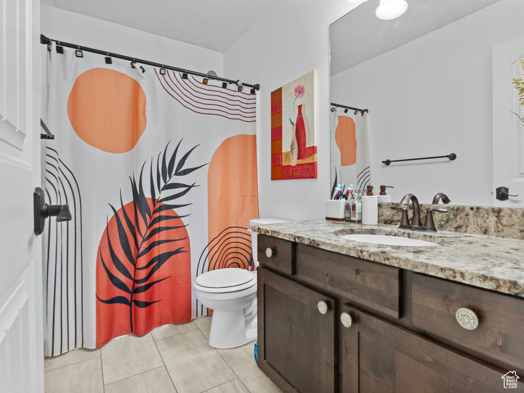 Bathroom featuring tile patterned flooring, vanity, and a shower with shower curtain