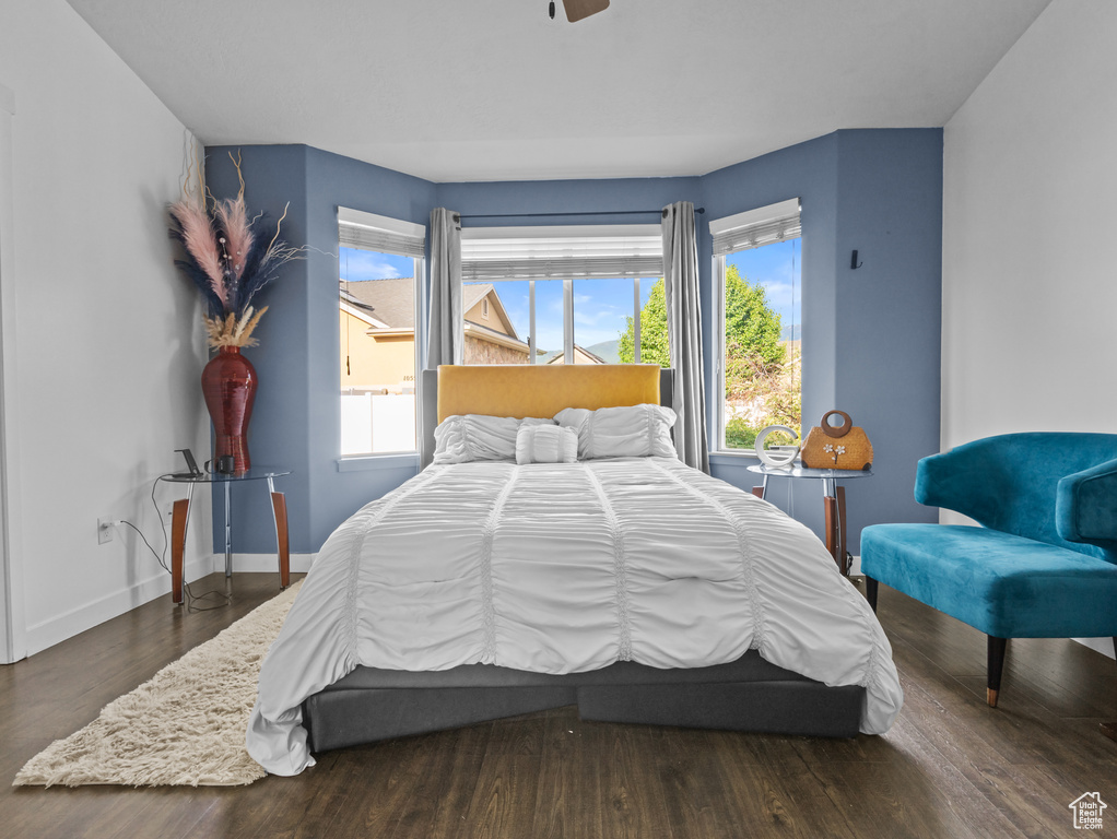 Bedroom with wood finished floors and baseboards