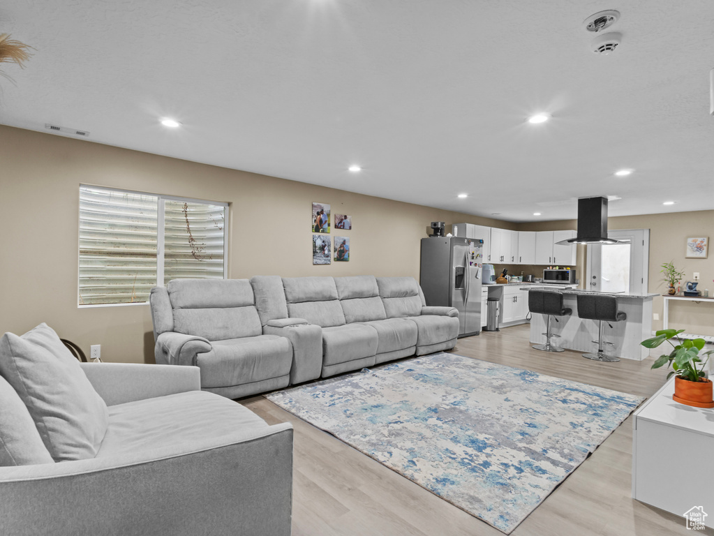 Living room with light wood finished floors and recessed lighting