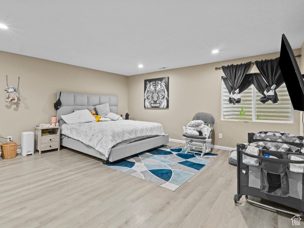 Bedroom with wood finished floors and recessed lighting