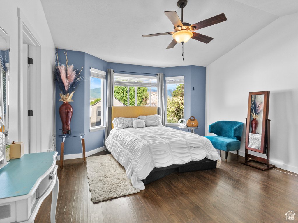 Bedroom with wood finished floors, ceiling fan, and lofted ceiling
