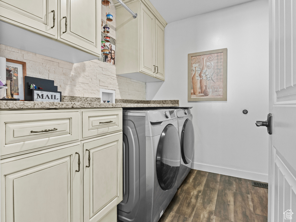 Laundry area featuring cabinet space, separate washer and dryer, and dark wood-style floors