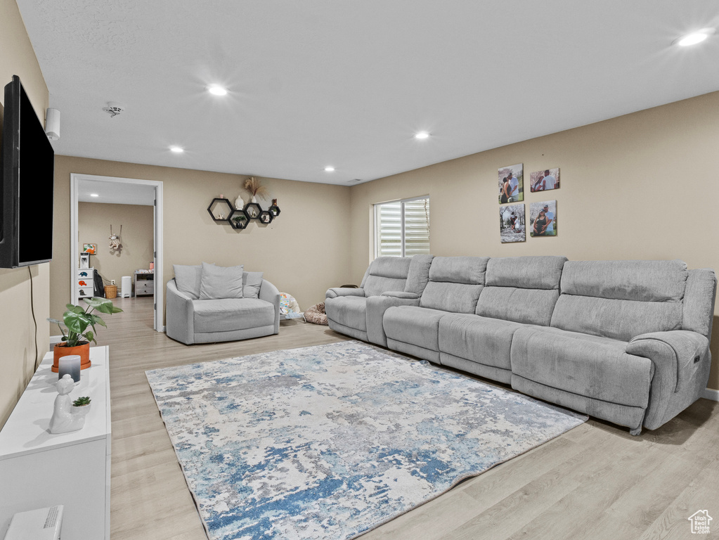 Living room with light wood-style floors and recessed lighting