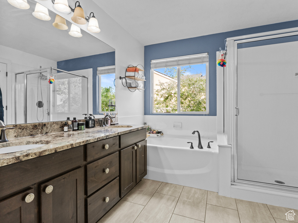 Full bath featuring a stall shower, a bath, and double vanity