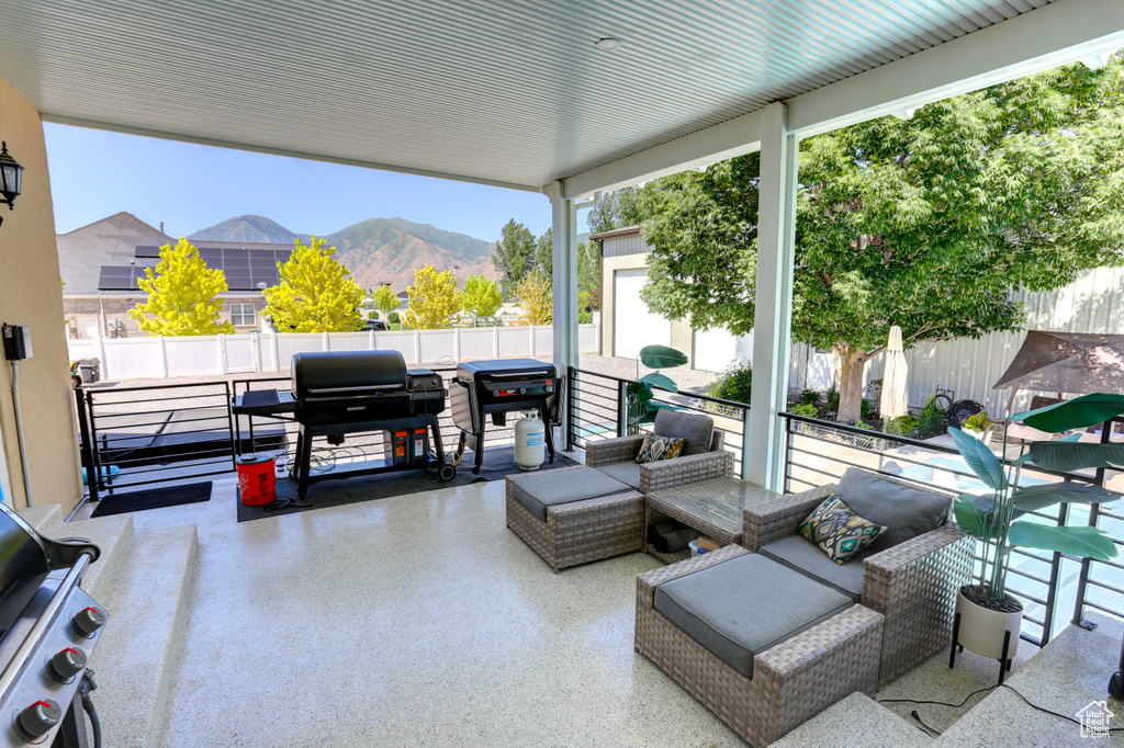 Fenced backyard featuring a mountain view, a patio, and a grill