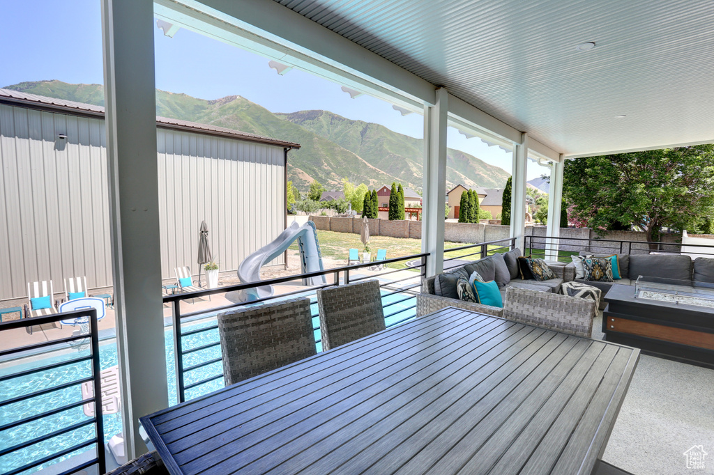 Deck featuring outdoor lounge area, a mountain view, and a fenced backyard