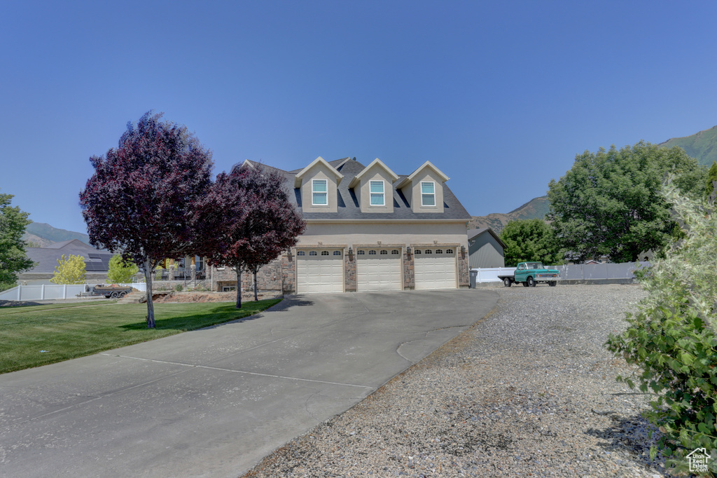 View of front of house with asphalt driveway, an attached garage, and a mountain view