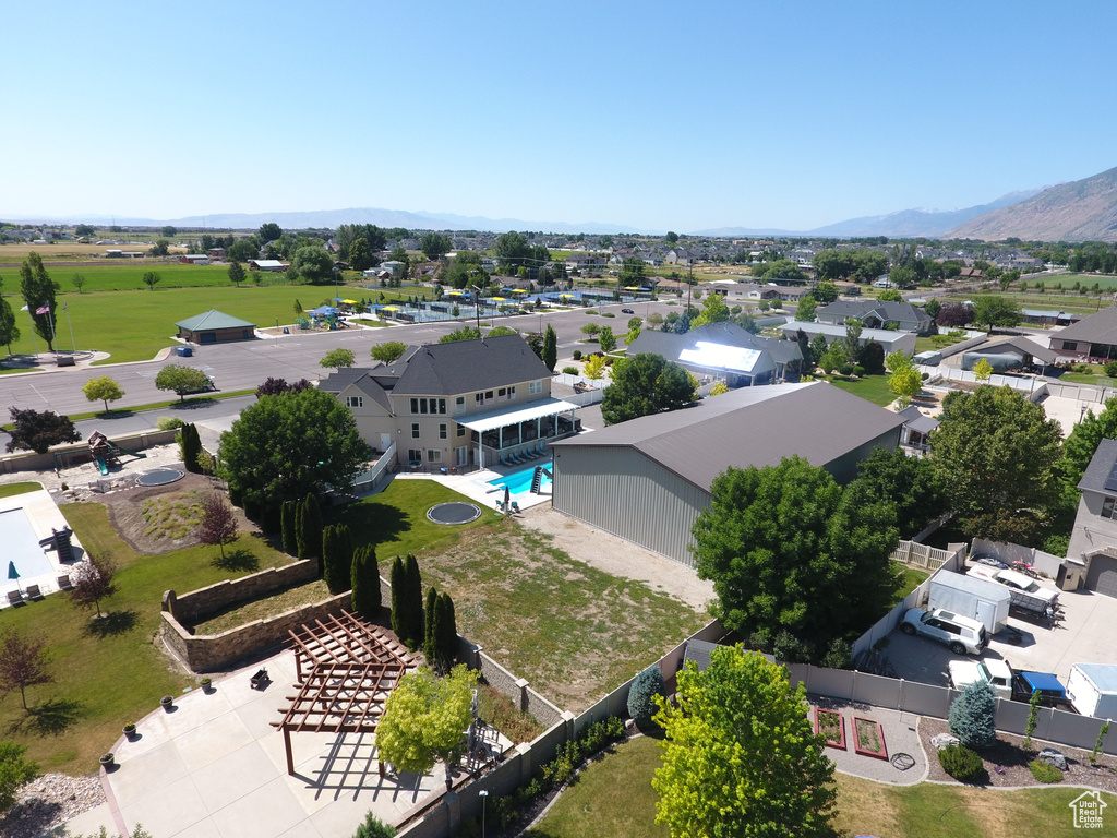 Aerial perspective of suburban area featuring a mountain backdrop and a pool area