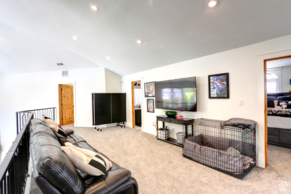 Carpeted living area featuring lofted ceiling and recessed lighting