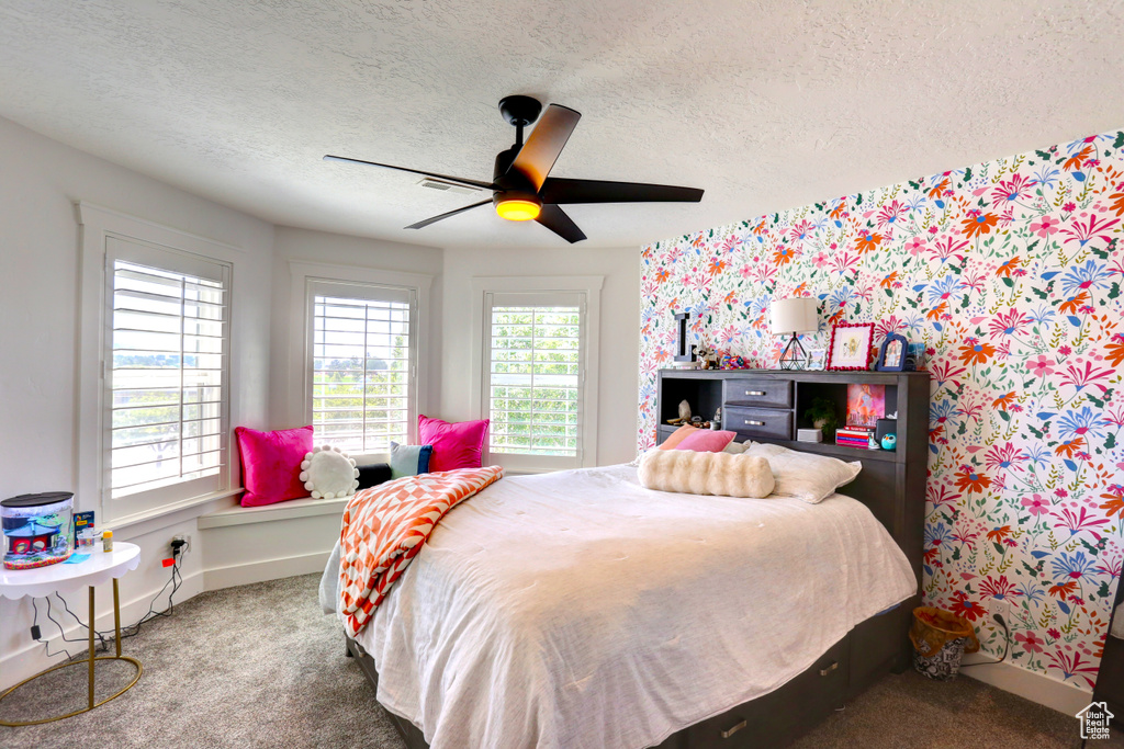 Bedroom featuring carpet flooring, a textured ceiling, ceiling fan, and wallpapered walls