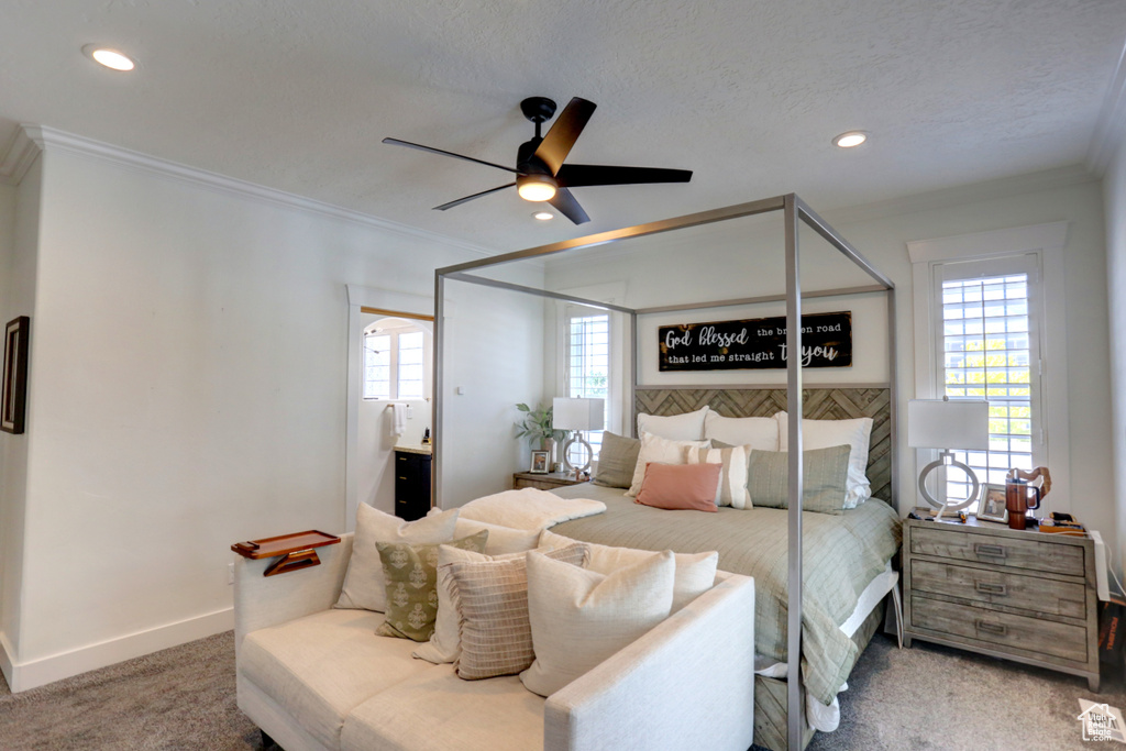 Carpeted bedroom featuring multiple windows, ornamental molding, recessed lighting, a ceiling fan, and connected bathroom