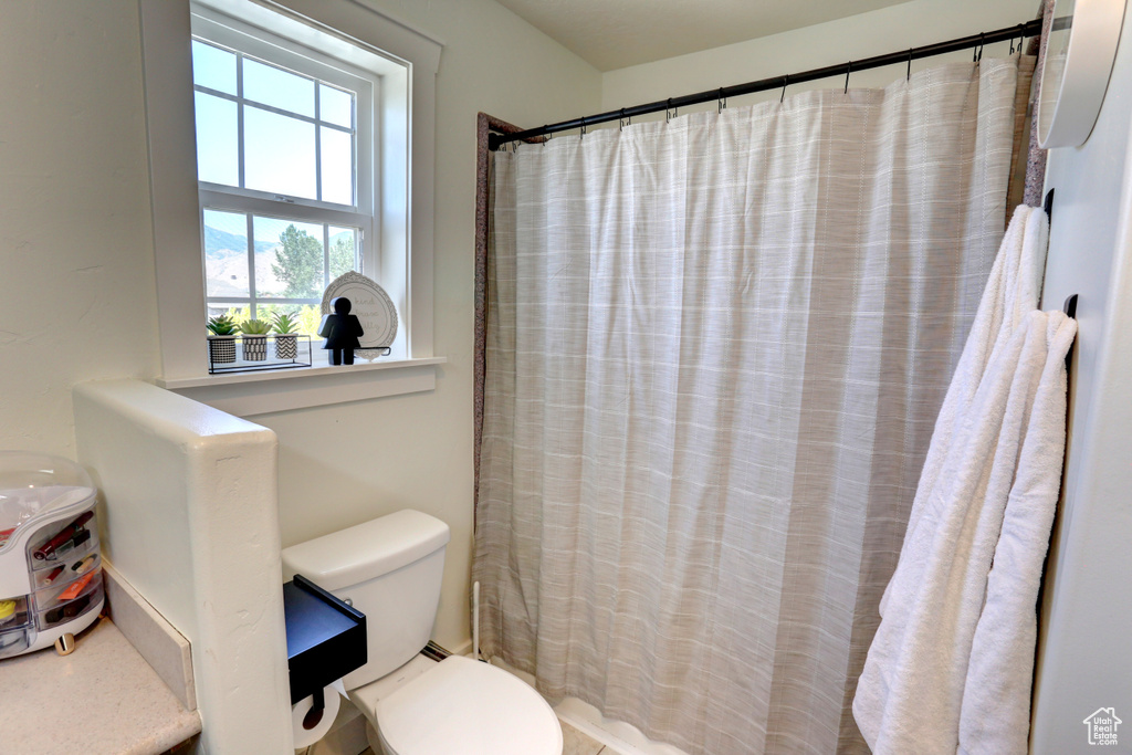 Bathroom featuring toilet and a shower with curtain
