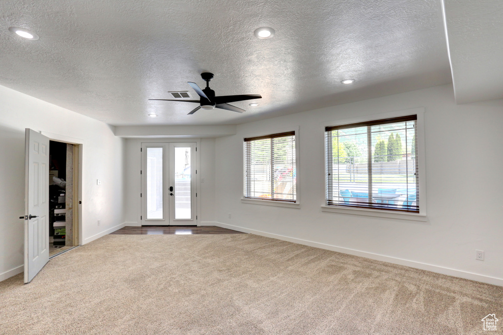 Carpeted spare room with a textured ceiling, ceiling fan, and recessed lighting