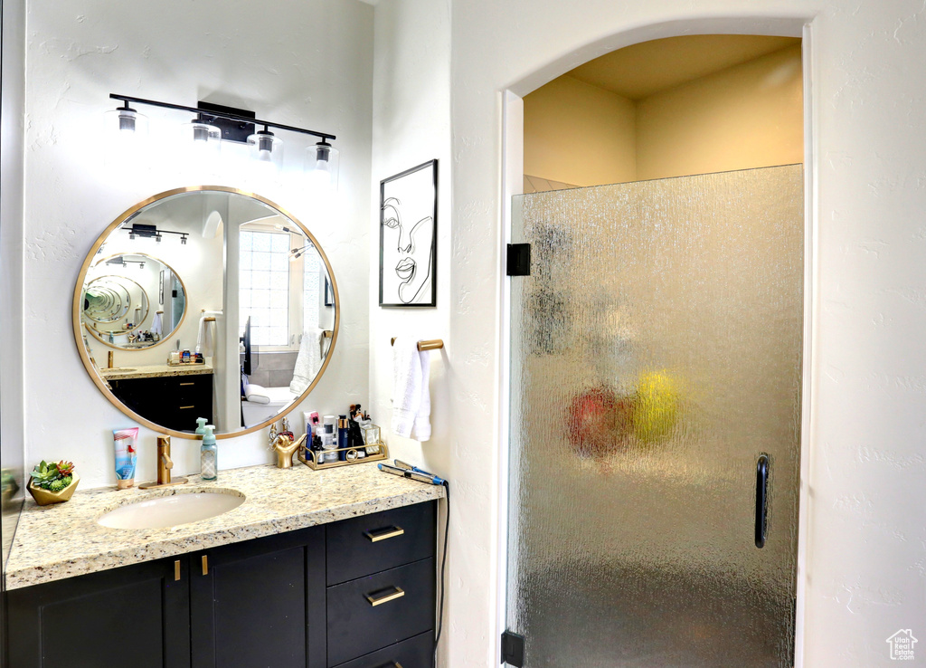 Full bath featuring a stall shower and vanity