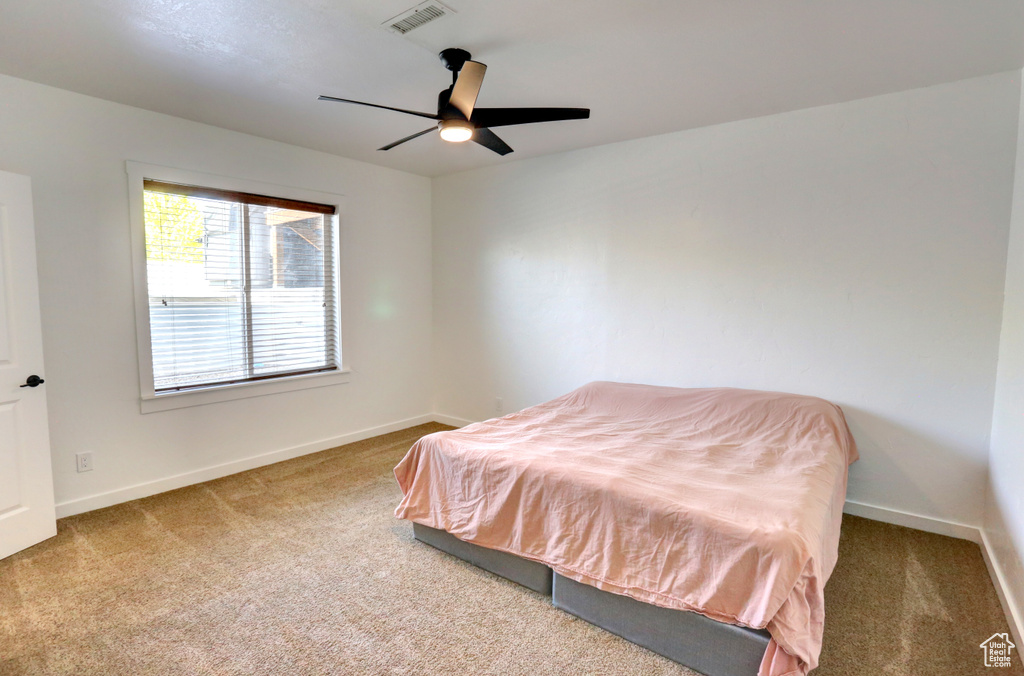 Carpeted bedroom with baseboards and ceiling fan
